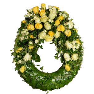 En rund krans dekorerad med gula och vita rosor samt gröna blad.