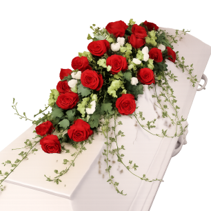 Röda rosor och vita blommor arrangerade på ett vitt träkistlock.